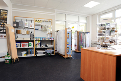 Innenansicht vom Laden Raumausstatter Swen Rohnke - mit Blick auf Stoffmuster für Gardinen und Malerutensilien